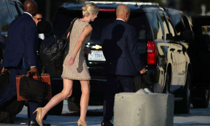 Natalie Harp strides after Donald Trump with humongous black bag slung over shoulder